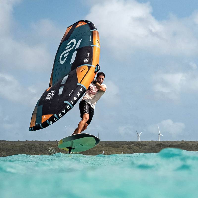 Pierre, coach de kitesurf et créateur YouTube, explique avec les mains un point technique face à Peter Stiewe, en pleine discussion